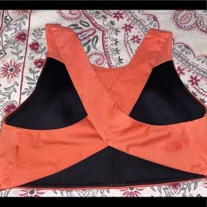 The North Face: orange criss cross sports bra